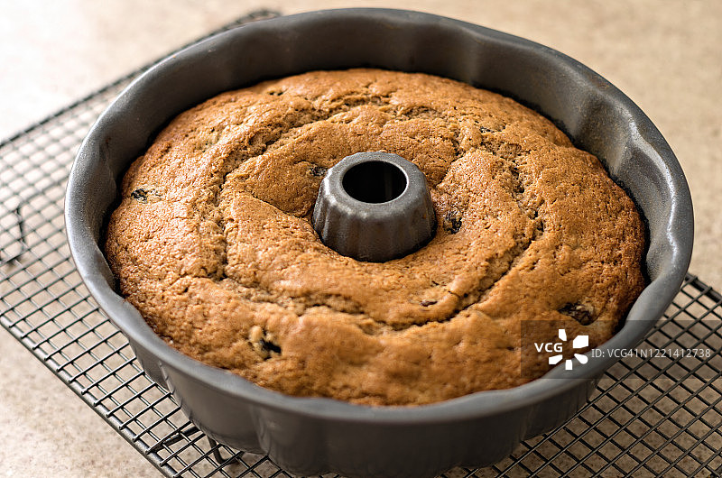 冷却架上蛋糕罐头里的新鲜出炉的自制朗姆酒和葡萄干邦特蛋糕图片素材
