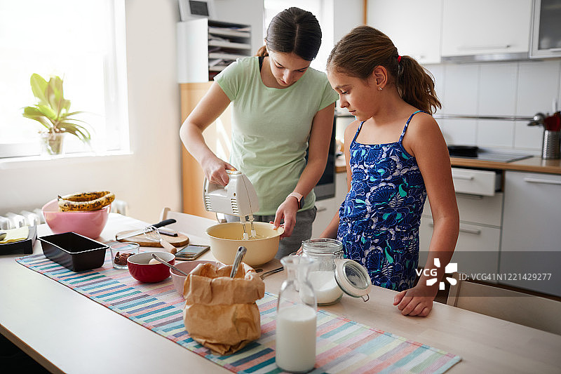 姐妹在厨房做香蕉面包图片素材