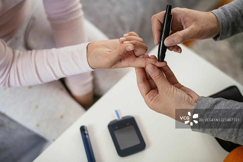 用血糖仪测量女孩血糖水平的库存照片图片素材
