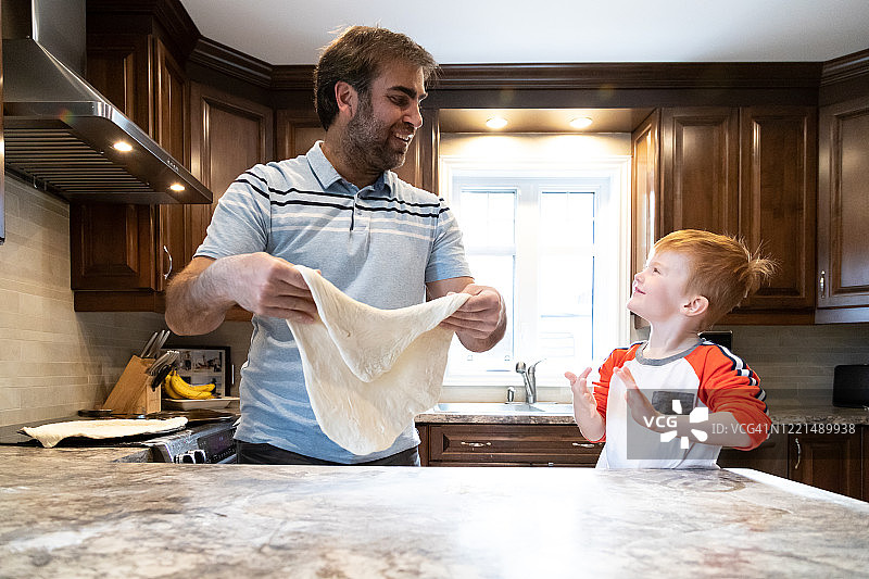 父亲和小红发儿子一起做自制披萨图片素材