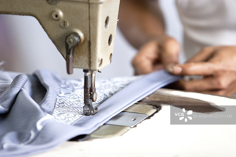 服装厂工人缝纫衣服的特写图片素材