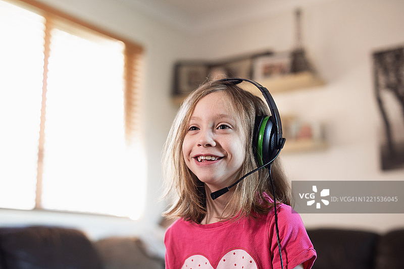 戴着耳机在线玩游戏的小女孩图片素材