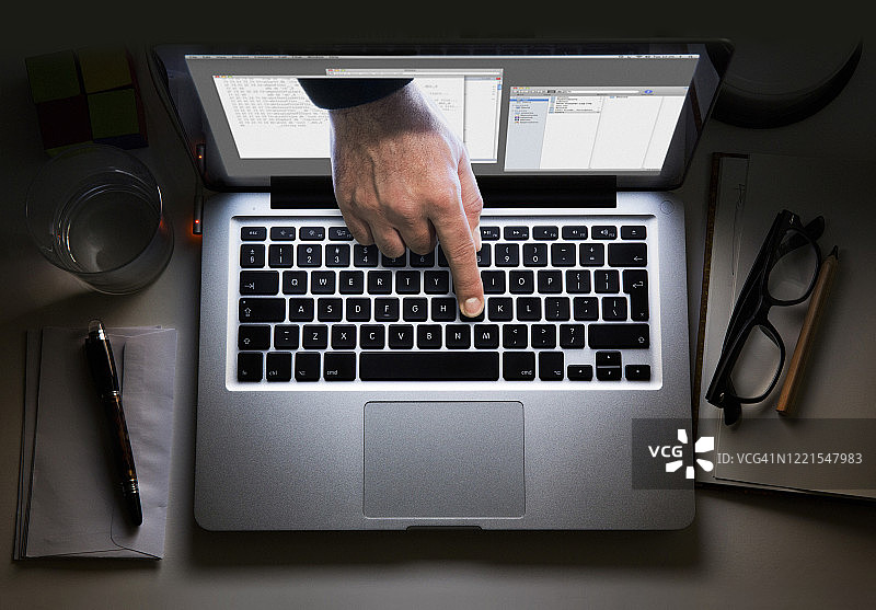 从笔记本电脑屏幕中伸出的手，触摸键盘图片素材