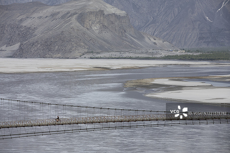 骑摩托车穿越印度河的男子图片素材