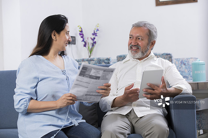 情侣坐在客厅的沙发上（库存照片）图片素材