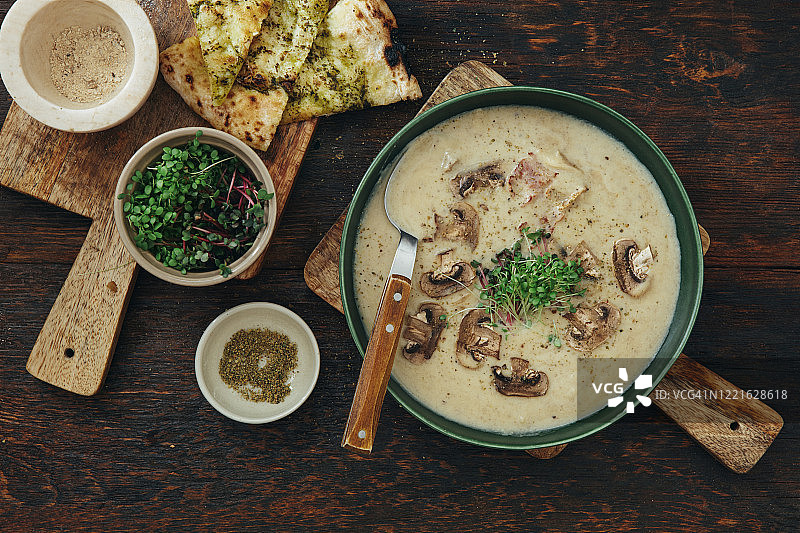 深色木纹背景上的烤蘑菇和花椰菜汤图片素材
