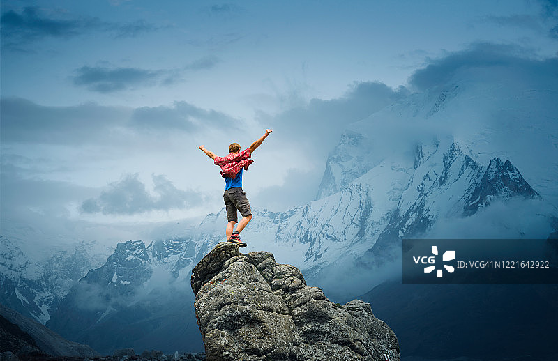 在山顶上表达胜利的强壮男人图片素材