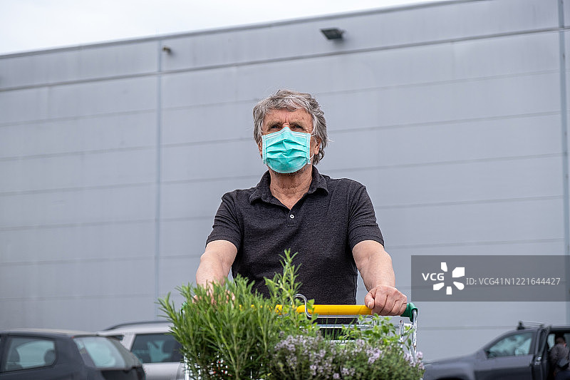 戴口罩的老人推着购物车购物图片素材