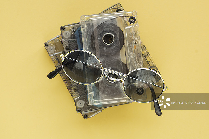 黄色复古背景上的磁带和复古太阳镜图片素材