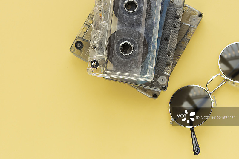 黄色复古背景上的磁带和复古太阳镜图片素材
