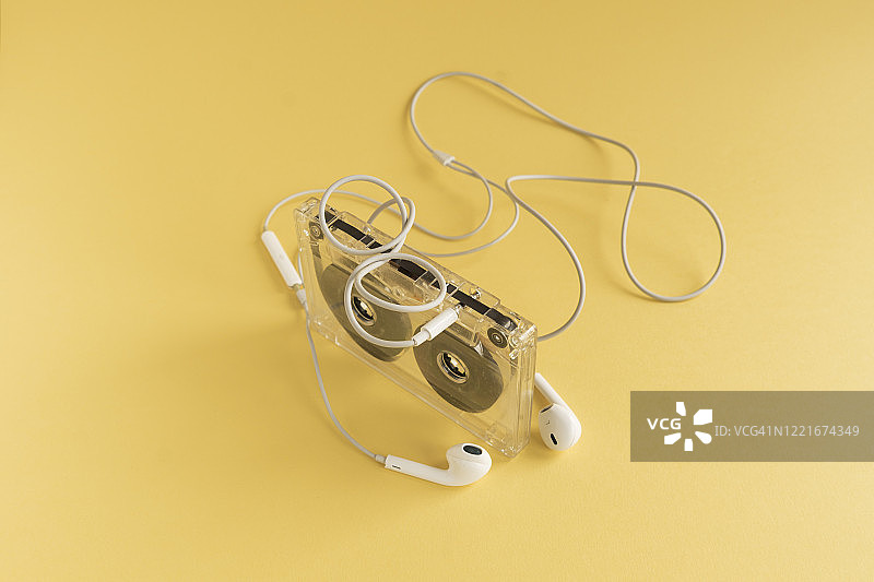 复古录音带与入耳式耳机，黄色背景。音乐图标。图片素材