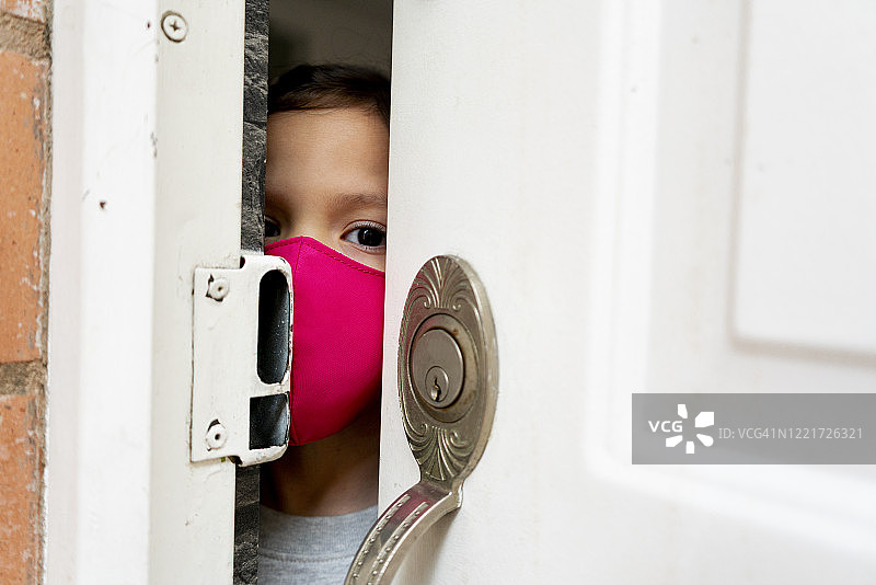 戴着口罩打开房门的5岁女孩图片素材