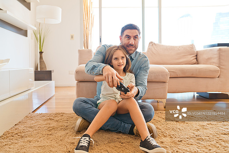 女孩和父亲一起玩电子游戏图片素材