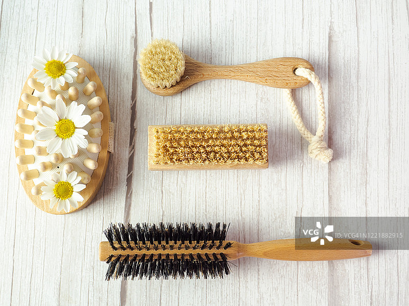 白色木桌上带有鲜花的木刷和文本的底片空间图片素材