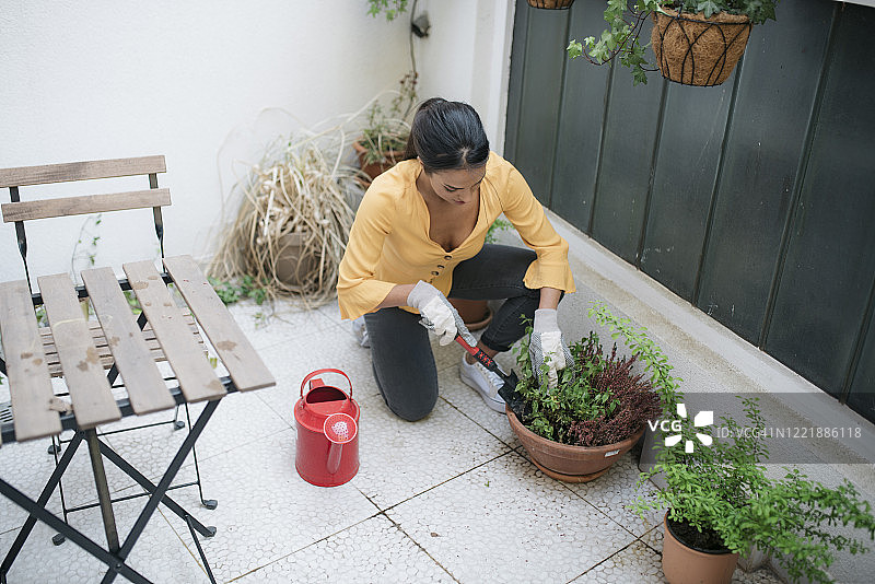 一位年轻女子，在她的家中精心照料着花园图片素材