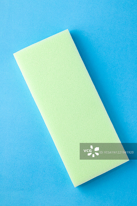 蓝色地板上的浅绿色清洁海绵图片素材