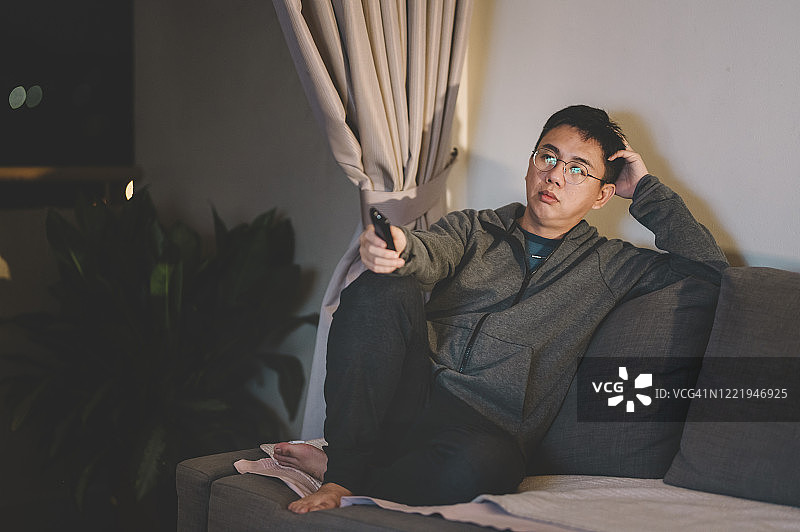 独自在家看电影的亚洲中年男子图片素材