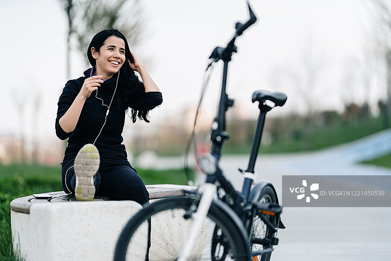 骑自行车前伸展腿部的年轻女人图片素材