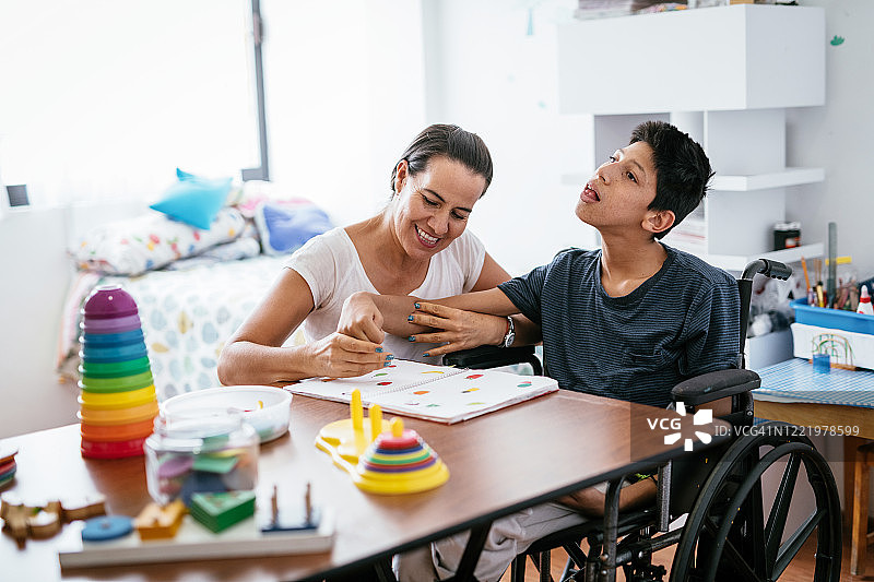 新冠疫情期间母亲在家教患有脑瘫的儿子图片素材