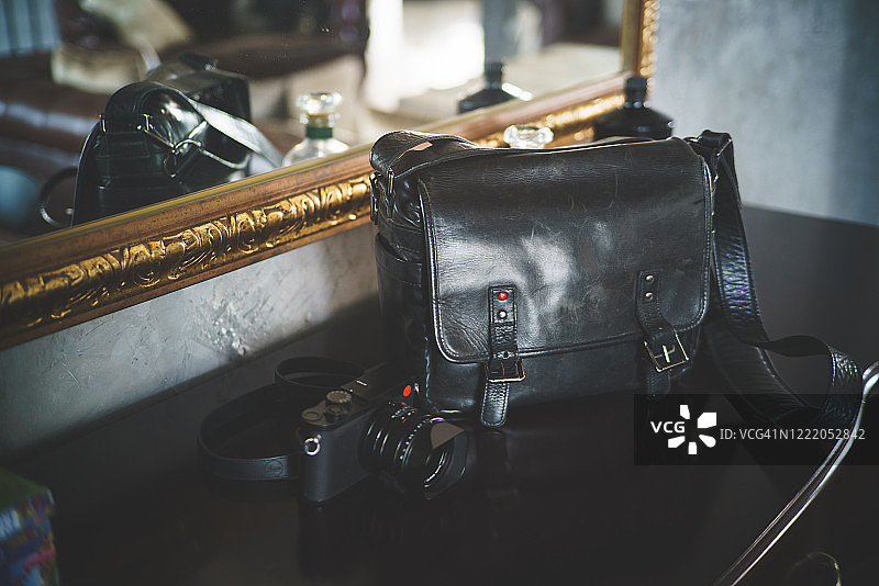 木柜上的黑色相机和黑色皮包图片素材