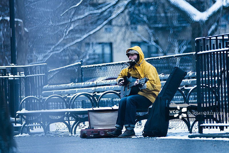 坐在公园长椅上卖艺的音乐家图片素材