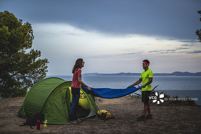 在地中海沿岸准备露营地的活力情侣图片素材