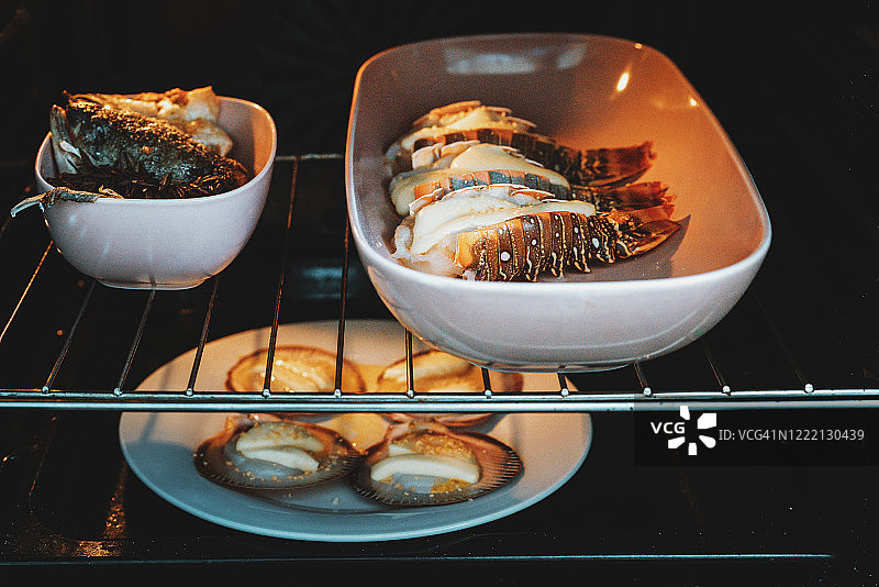 自制海鲜美食：烤龙虾尾、扇贝和三文鱼头图片素材