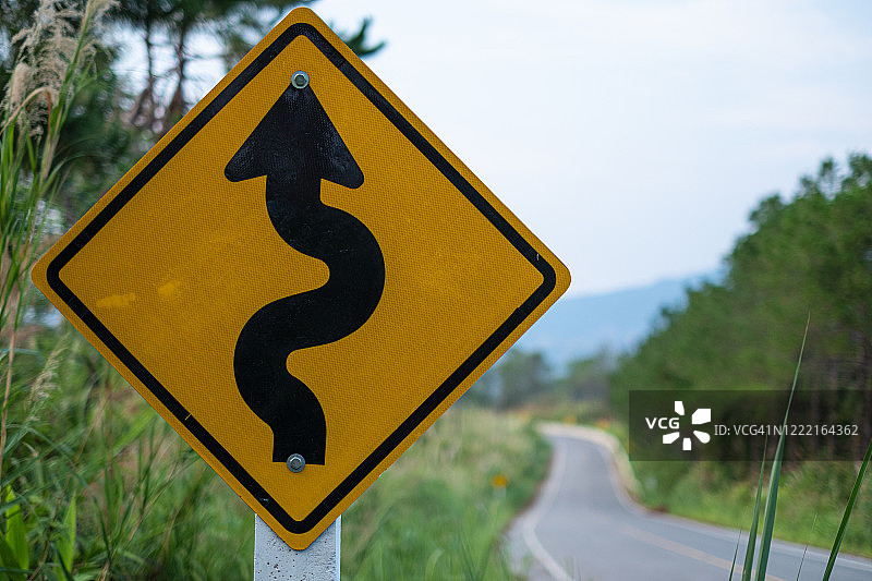 警告前方道路弯曲的黄色交通标志图片素材