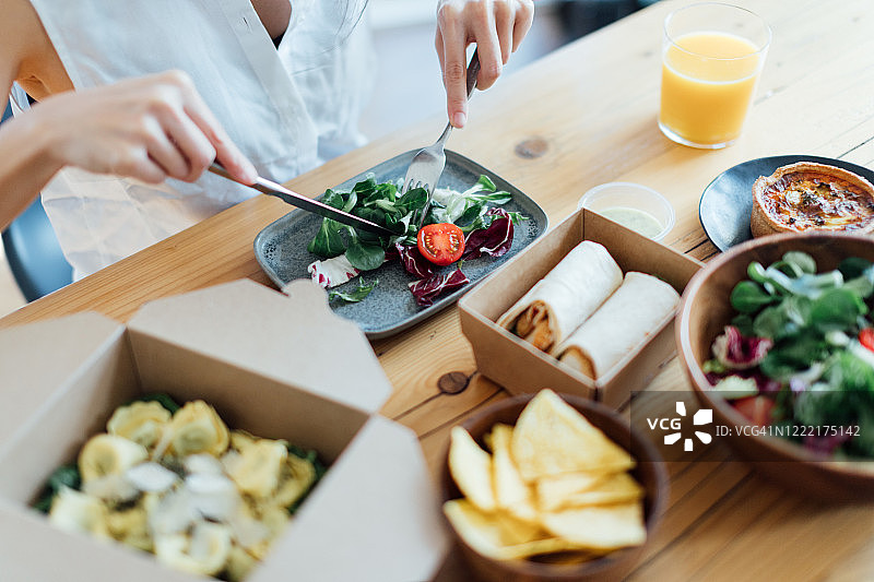 年轻女人在家吃健康外卖图片素材