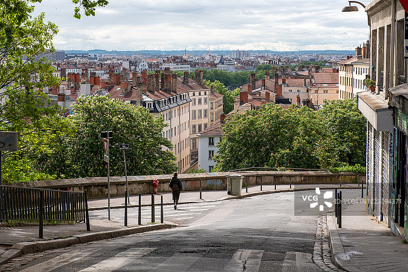疫情封锁期间独自走在法国里昂街头眺望全景的女人图片素材