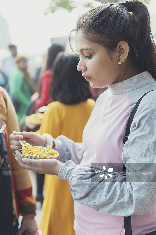 女孩们愉快地享用街头小吃图片素材