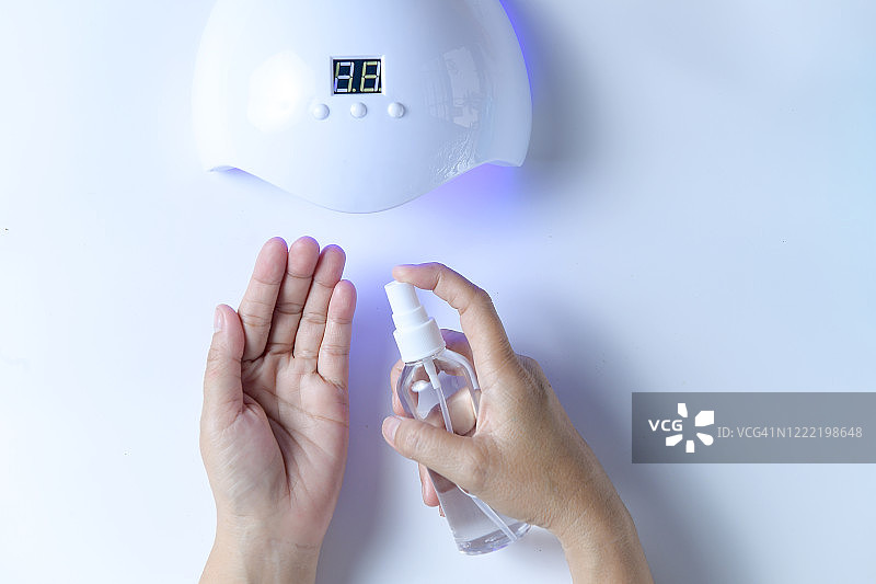 女人使用洗手液和紫外线灯图片素材