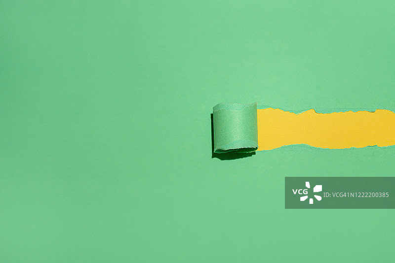黄色背景上的绿色粗糙撕纸图片素材