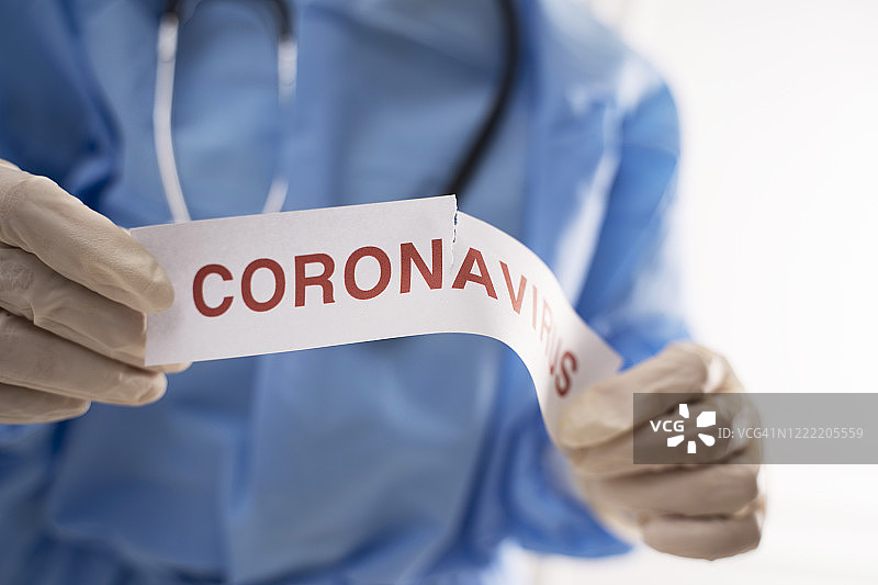 医生撕毁带有冠状病毒字样的纸图片素材