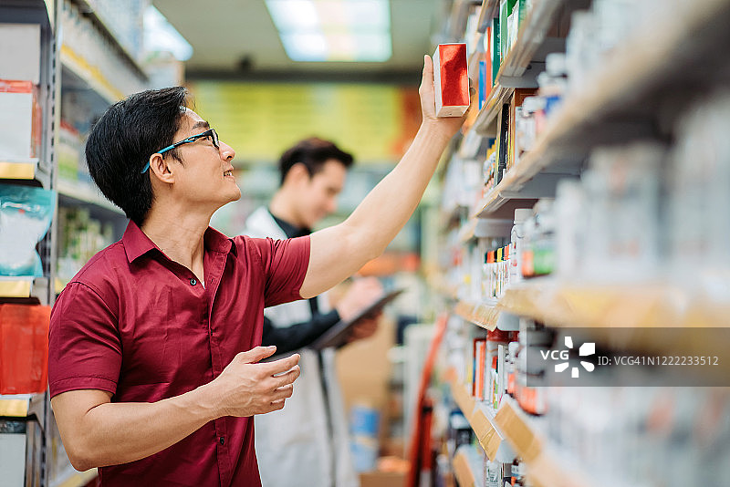 中国男顾客在药房货架上挑选商品图片素材