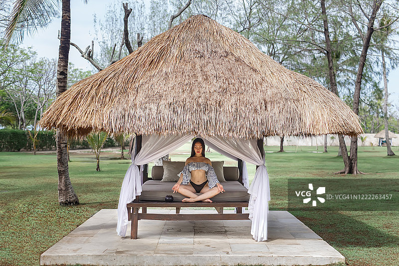 美丽的亚洲女孩在凉亭里冥想图片素材