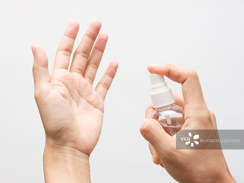 在白色背景上手部喷洒酒精图片素材