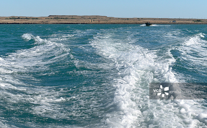 波斯湾的格什姆岛和弓形波浪中航行的船只，霍尔木兹海峡，伊朗图片素材