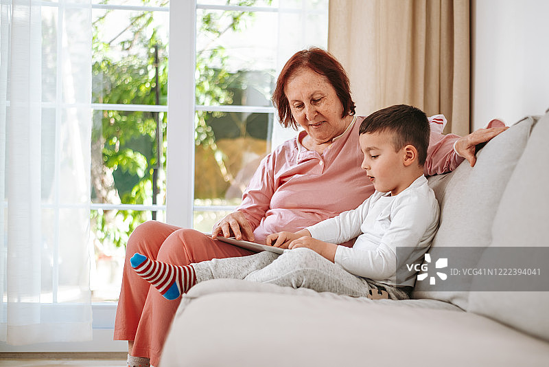 祖母和孙子在家里的起居室玩拼图游戏图片素材