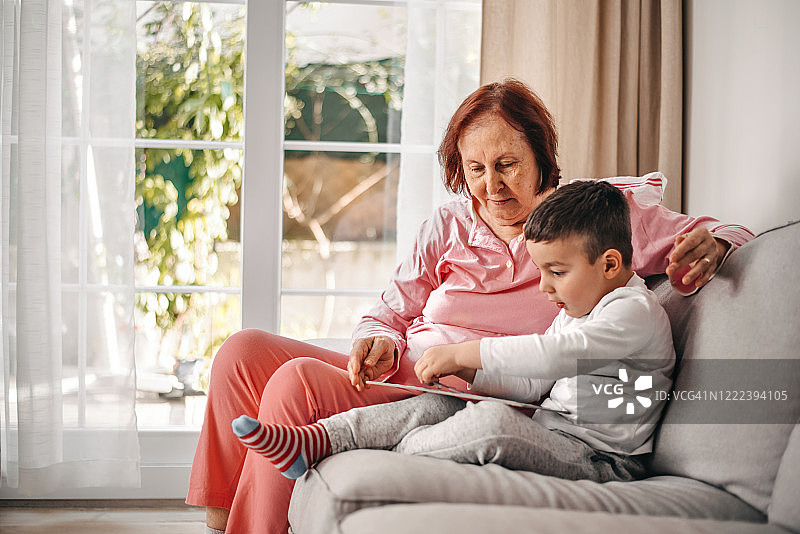 祖母和孙子在家里的起居室玩拼图游戏图片素材