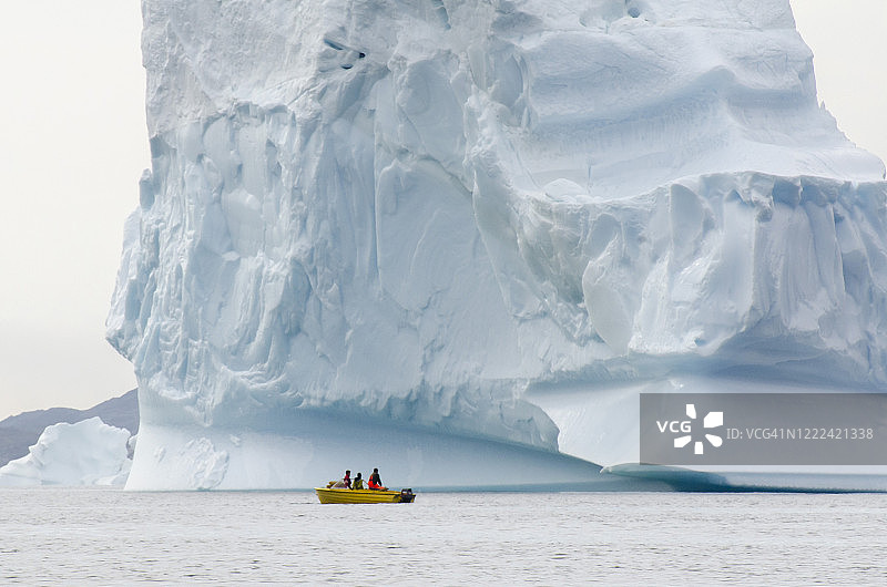 巨大的冰山笼罩着一艘渔船图片素材