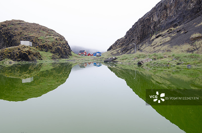 平静海湾的村庄和山脉倒影图片素材