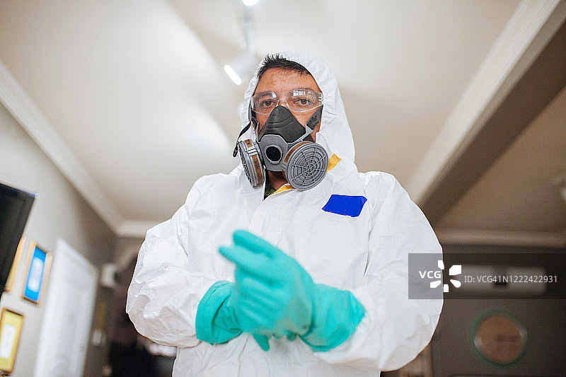 身穿防护服的男子在对建筑物内的每个房间进行消毒和喷洒图片素材