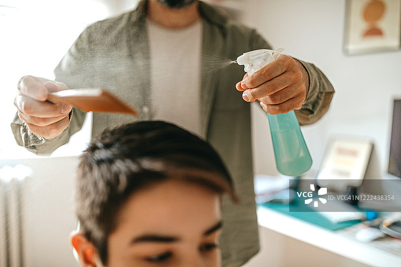 男人在家给儿子理发图片素材