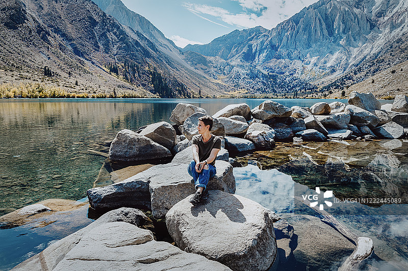 中年妇女坐在美国康维克特湖的岩石上图片素材