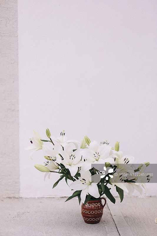 地面上白色百合花束的正面图图片素材