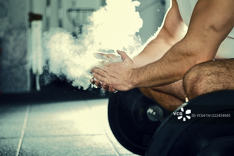 举重运动员在健身房举重前拍手图片素材