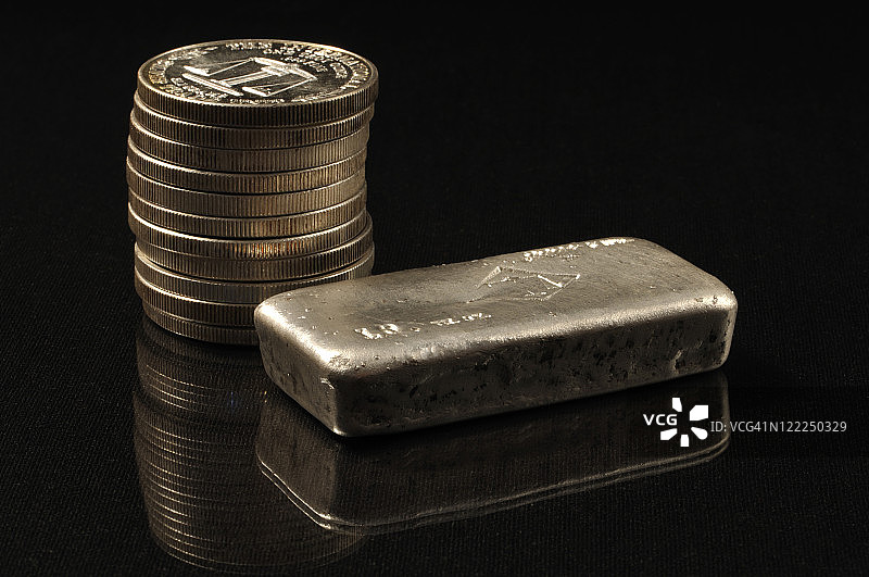 银币堆旁的银条图片素材