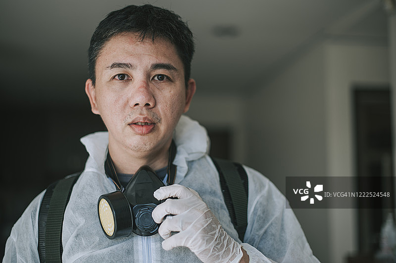 中国中年男子消毒后摘下防护服休息，脸上留有痕迹，略显疲惫图片素材
