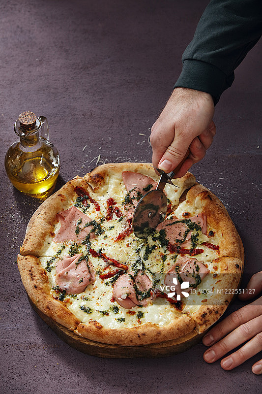 男人切割意大利披萨图片素材